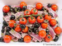 Oliven und Marinade sowie Tomaten einfüllen