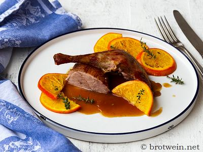 Angerichtet: Entenkeule und Stück Entenbrust mit Orangensauce und den Deko-Thymian-Orangenscheiben