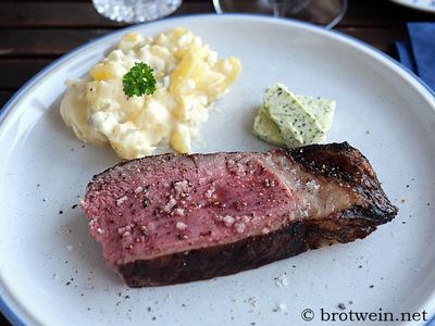 Gegrilltes Tomahawk Steak mit Beilagen servieren