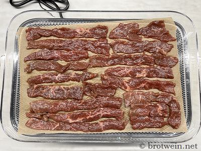 Fleisch mit Folie auf das Dörrgitter geben